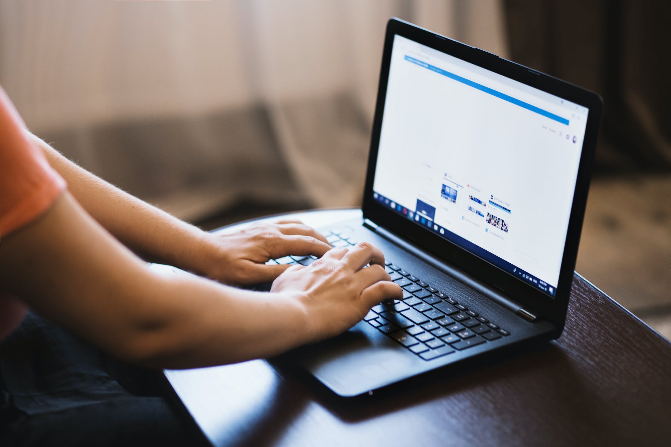 Hands typing on a laptop